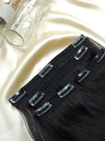 A beautiful set of 4 premium clip-on hair extensions, laid out to show their quality and natural shine. These are ready to be customized for a client.