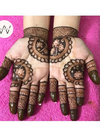 A designer lotus mehndi with multiple mandalas on the palm and fingers.