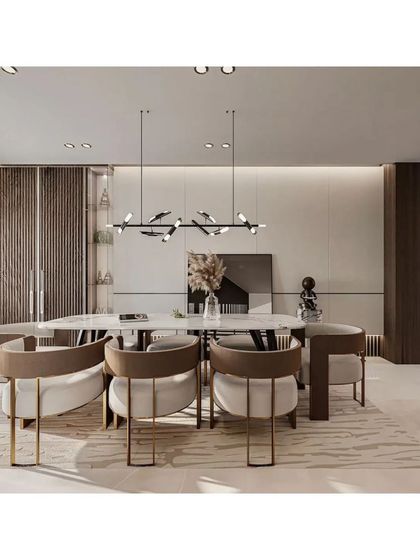 This modern dining area is defined by its sleek, minimalist aesthetic. The bird-inspired pendant light adds an artistic touch above the marble-topped table, while wood-paneled walls provide texture and warmth.