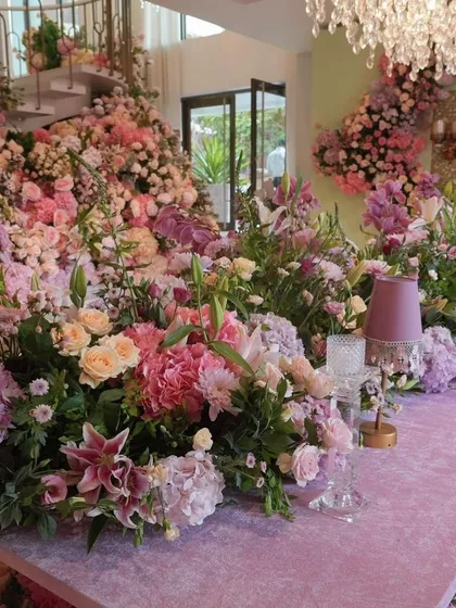 An opulent floral tablescape for Radhika Merchant's royal-themed bachelorette party, featuring a sea of pink, purple, and peach flowers.