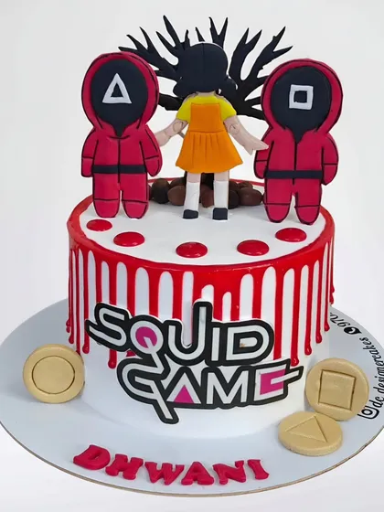 A Squid Game-themed cake based on the popular Netflix series. This whipped cream cake includes the iconic guards, the Dalgona candy shapes, and the show's logo for a trendy birthday.