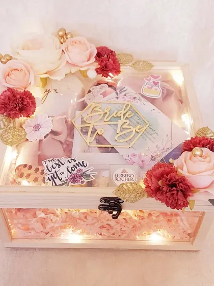 A 'Bride to Be' hamper that glows. This wooden keepsake box is lit with fairy lights and filled with treats and a custom tag, creating a magical unboxing experience for the future bride.