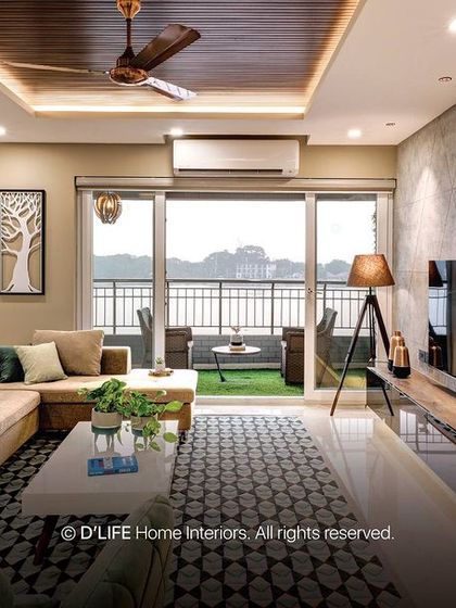 This living room with a balcony view uses a neutral color palette for the sofa and walls, allowing the stunning exterior view to be the main focus.