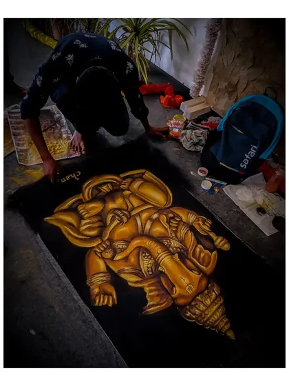 This photo shows me giving the final touches to my Lord Ganesha rangoli. Creating spiritual art like this is a meditative process, and I am honored to make these pieces for festivals and sacred occasions.