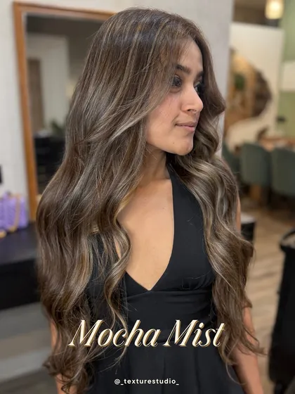 This is my signature sun-kissed look. The Mocha Mist balayage gives you soft, face-framing highlights that grow out seamlessly. It's the perfect low-maintenance color for a natural, radiant glow.