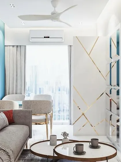 This design concept shows a modern living space from another perspective. A custom white partition with gold inlay adds a touch of glamour and helps define the entryway without closing off the room, maintaining an open and airy feel.