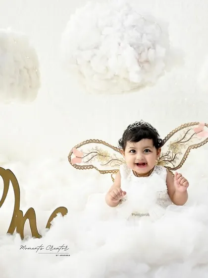 Thumbs up for being one! This little angel's happy gesture and bright smile make this one of the most joyful and adorable photos.