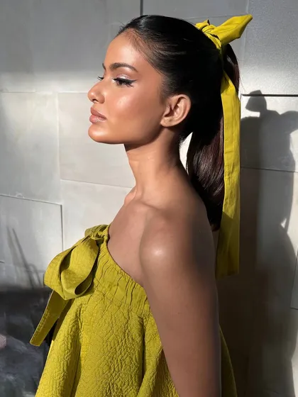 A side profile showing off the clean lines of the half-eyeliner and the sleek ponytail. This is a fresh, trendy, and modern look.