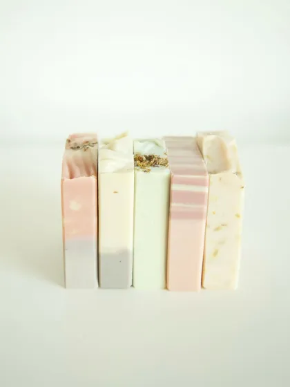 A beautiful lineup of five different soap variants, showcasing the range of natural colors and textures I create.