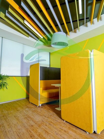 The same office space, but with a vibrant yellow and lime green color scheme. The tall Bird of Paradise and palm plants in white planters complement the bright, energetic feel of this collaborative pod.