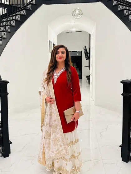 A stunning client in a classic red velvet kurti paired with a white embroidered sharara skirt. This is a perfect example of how we can mix and match pieces to create a timeless and elegant festive look.