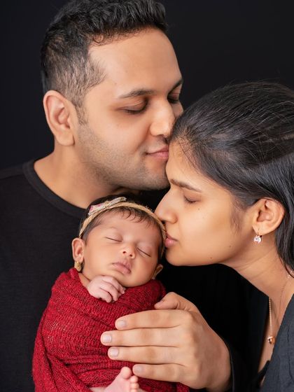 The color version of the previous portrait, showing the warmth of their skin tones and the rich color of the baby's wrap.
