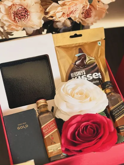 A classic Valentine's gift for him, featuring a Zara wallet, Red Label and Black Label miniatures, and Hershey's Kisses, adorned with beautiful roses.