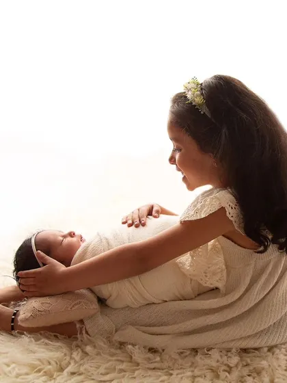 Their divine love. This beautiful moment between two sisters just melts my heart. The way big sister looks at her new baby is pure magic.