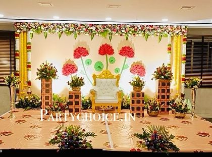 A full view of the unique half saree ceremony stage, showing the combination of modern art and traditional floral arrangements.