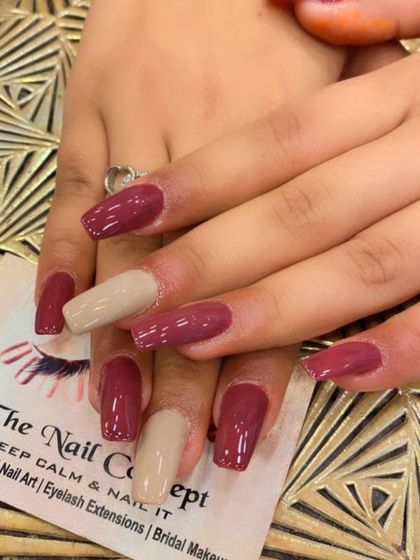 A sophisticated color-block design on square nails. This set features a mix of deep mauve and nude-colored nails for a modern and chic look.