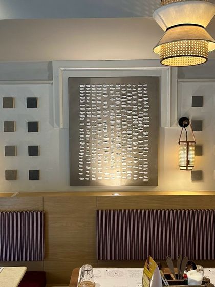 The textured dash-patterned piece installed at the Agra cafe. The lighting is designed to graze the surface and highlight the 3D texture.