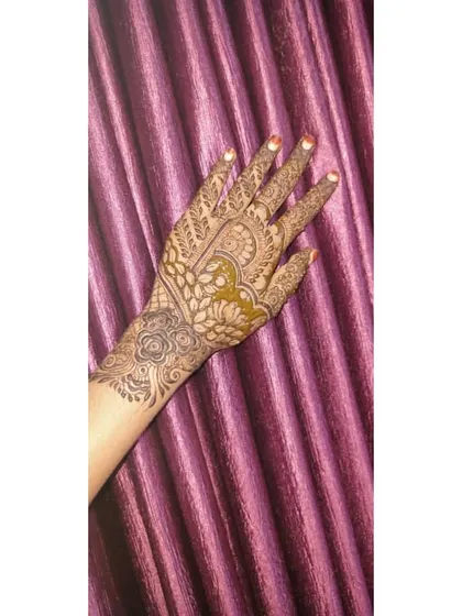 A beautiful party henna design with a mix of floral and paisley elements, with some parts filled in for a bolder look.