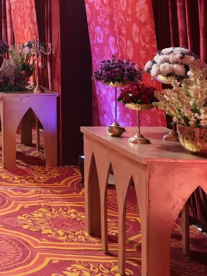 A look at the decor lining the main walkway, with wooden consoles holding beautiful floral arrangements in brass vases, adding to the royal theme.