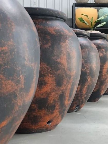 A lineup of my terracotta planters in a dramatic black and burnt orange finish, showcasing their bold, rustic appeal.