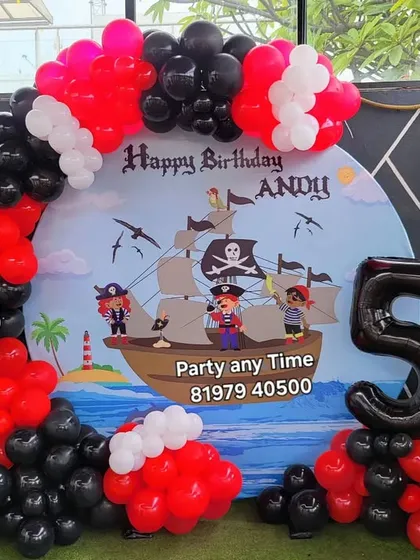The full pirate theme setup, complete with a treasure chest prop and a large number '5' foil balloon. Perfect for an adventurous birthday boy.