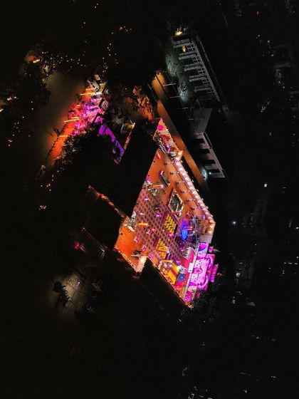 A top-down night shot of a wedding venue, showing the colorful lighting of the outdoor and indoor event spaces.