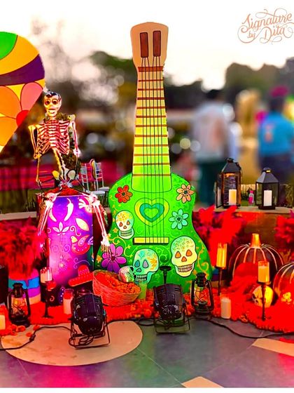 The 'Coco' guitar prop lit up at dusk with spotlights. Proper lighting is essential to make sure the decor is just as impactful at night as it is during the day.