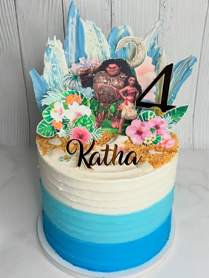 We love bringing your kids' favorite characters to life! This Moana-themed birthday cake features an ocean-inspired blue ombre design, crushed biscuit sand, and custom toppers to create a magical island scene.
