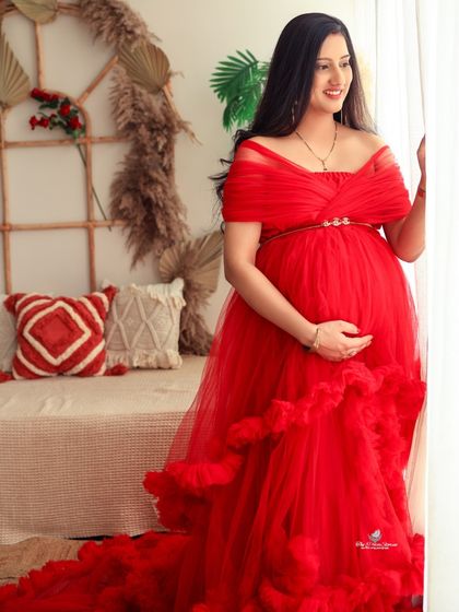 A contemplative and soft portrait by the window. The gentle natural light creates a beautiful, ethereal glow, highlighting the mom-to-be's profile.