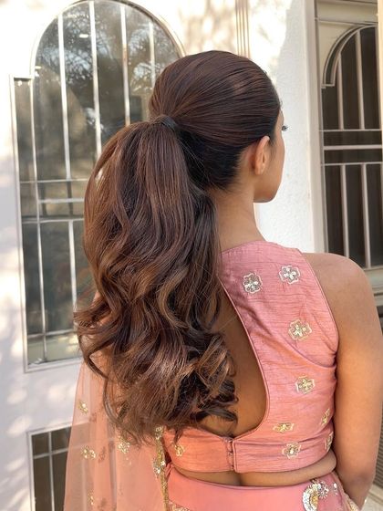 A back view of a classic high ponytail with soft waves. This is a timeless and elegant look for an engagement or Anand Karaj ceremony.