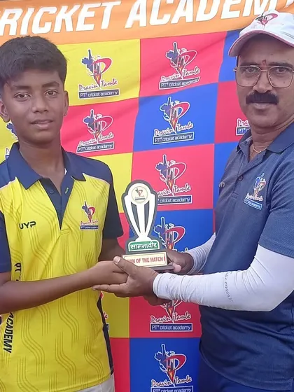 A coach presents the Man of the Match award to a U-14 player against the colorful backdrop of our academy banner.