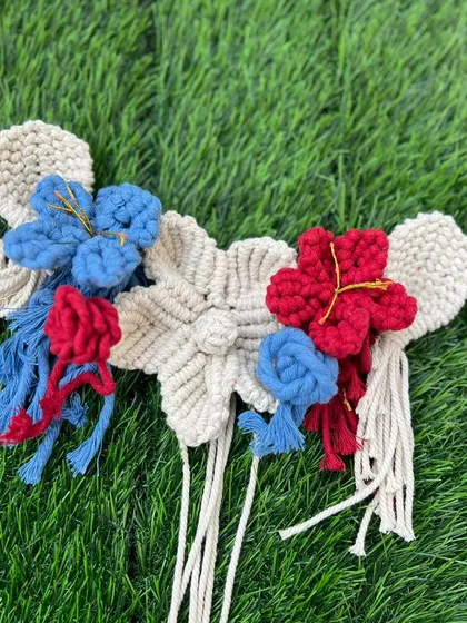 I also create macrame flowers that can be used to embellish other pieces. Here are red and blue flowers combined with a larger cream-colored flower.