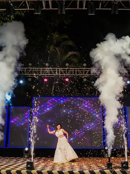 A spectacular solo dance performance by the bride on a grand stage with pyrotechnics and a dynamic LED backdrop.