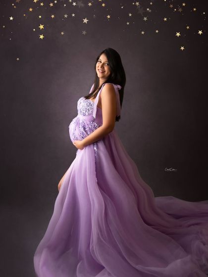 Another magical shot under a sky of stars. The mom-to-be smiles happily in her flowing lavender gown.