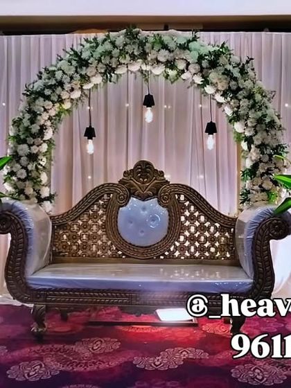 An all-white floral arch creates a look of pure elegance for this wedding stage. We used hanging Edison bulbs for a warm glow against the white drapes, making the setup feel both classic and contemporary.