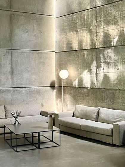 A quiet corner in the 'House of Stories'. The simplicity of the forms and the texture of the concrete walls create a serene atmosphere, where the focus is on the quality of light and space.