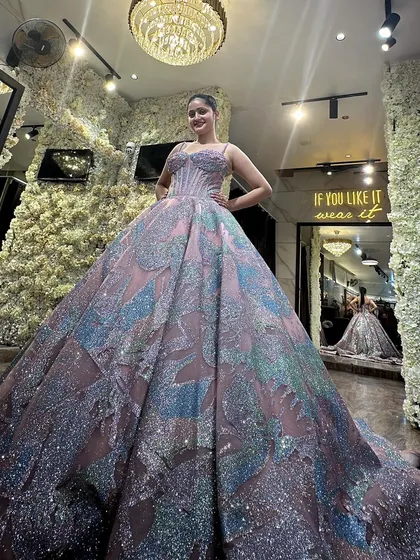 A client trying on our multi-colored pastel ball gown in the studio. Her happy expression shows the joy of finding a dress that makes you feel like a princess. The shimmering fabric and full skirt are truly breathtaking.