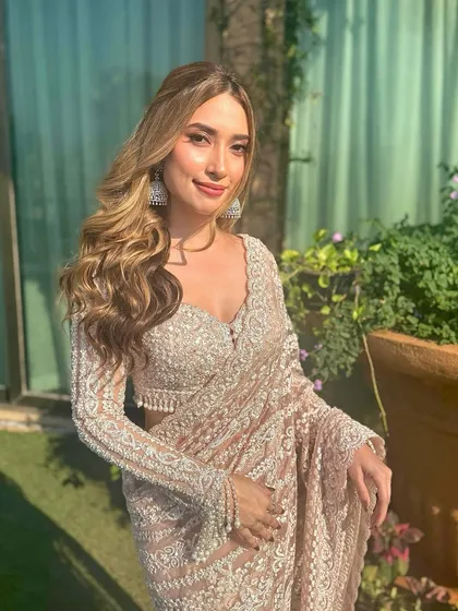 A close-up of this dreamy, dewy glam look. The soft waves frame her face beautifully, highlighting her features and the stunning details of her saree.