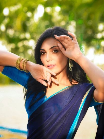 A powerful and direct gaze. This outdoor portrait in a blue saree combines traditional elegance with modern confidence.