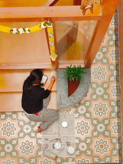 Another angle of me at work, focused on creating the clean, intricate lines of the Alpona design. It's a meditative process that requires a steady hand.