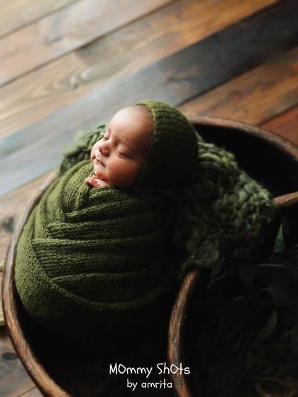 A beautiful example of using rich, earthy tones and textures with a newborn wrapped in an olive green knit.