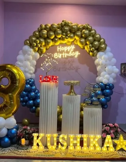 A blue, white, and gold balloon ring setup for a home birthday party.