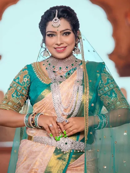 A smiling portrait of the model, showcasing the full AD set, including the choker, long necklace, and vaddanam.