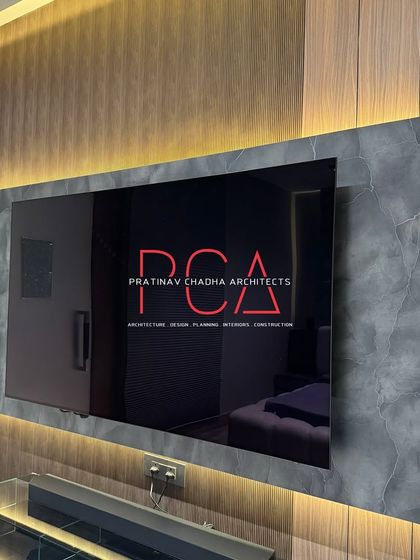 A close-up of the TV panel in the son's room, highlighting the texture of the stone-patterned laminate and the warm glow of the backlighting.