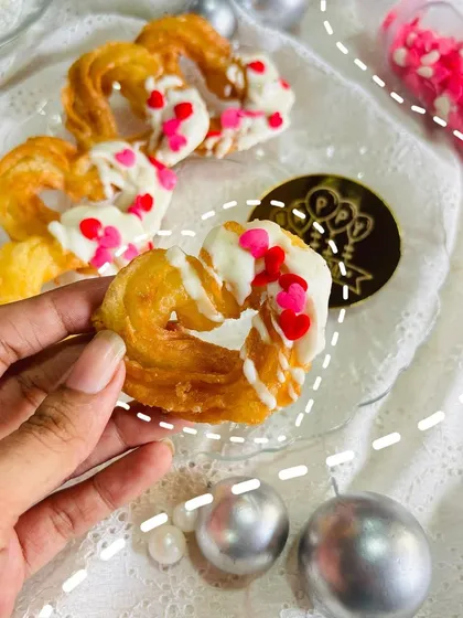 A stylized shot of me holding a heart-shaped churro, emphasizing the handmade and personal touch I bring to every order. This is more than just a dessert; it's a handcrafted gift made with love.