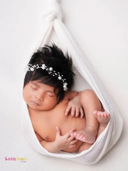 Another angle of the delicate sling pose, showing the baby's peaceful expression and beautiful thick hair.