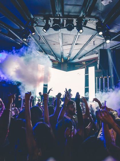 A powerful shot of the crowd with their hands up as smoke fills the stage. This captures the epic scale of a night at Flo.