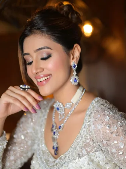 A happy and confident smile. This close-up shows the shimmering eyeshadow and the flawless finish of the makeup, which is designed to last all night.
