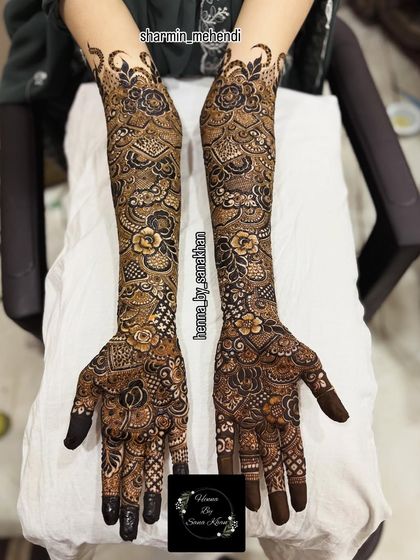 A complete view of a full bridal mehndi design, showcasing the rich detail and flawless symmetry from the fingertips to the elbows.