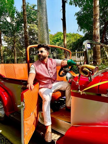 Taking a moment before the madness begins. Posing with the vintage car that was part of the baraat setup, blending classic style with modern beats.